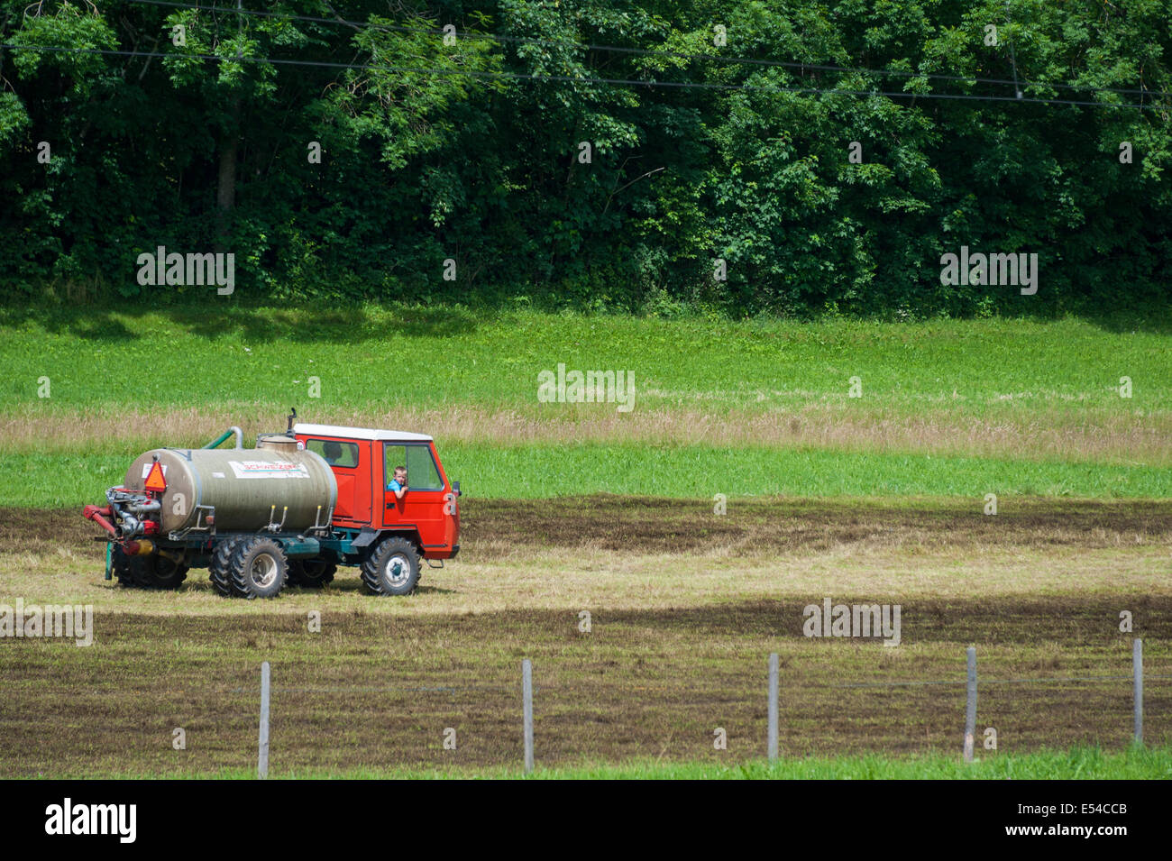A Swiss muckspreading tractor entering a field ready to start work Stock Photo