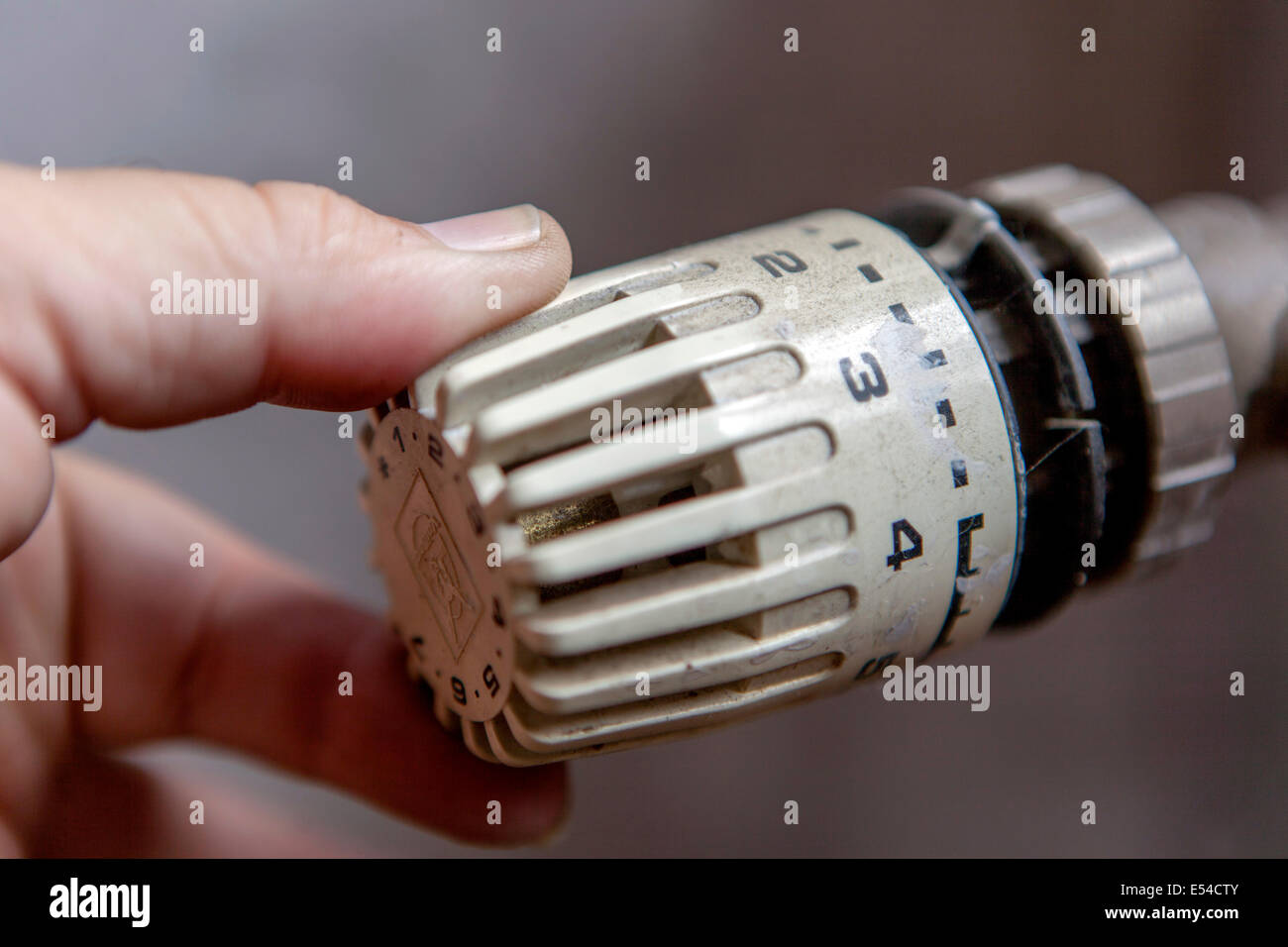 Close-up of person's hand using radiator thermostat at home temperature thermostat radiator Stock Photo