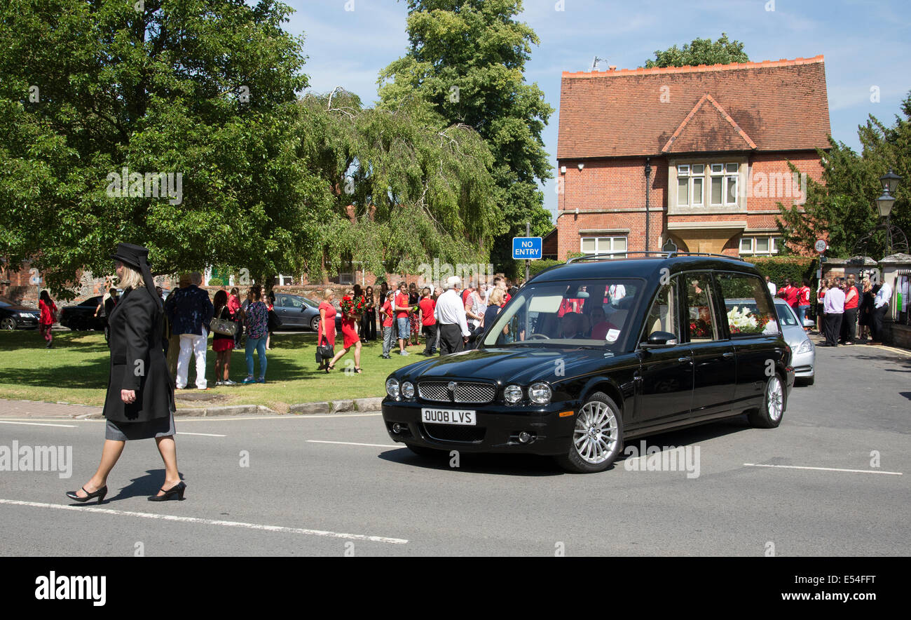 Jaguar hearse carrying a red and white coloured coffin in a funeral