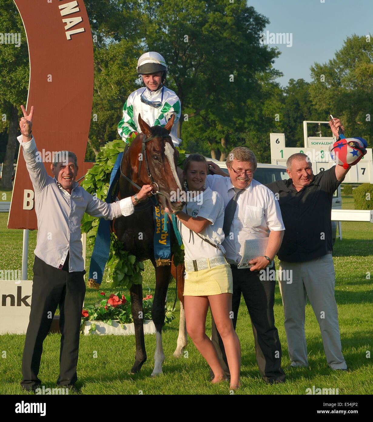 Bratislava, Slovak republic, July 20, 2014: Love Me (CZE) under the jockey Jan Verner (center), Mr. Allan Petrlik (trener, left) and other representatives of the winner team of Slovak derby 2014. 22 anniversary of a one of the biggest horse racing event in the Central Europe, Slovak derby was held in Bratislava, Slovakia. Horses and jockeys competed in nine different races the main of which was the Slovak derby itself with 60000 Euro prize. Credit:  Dmitry Argunov/Alamy Live News Stock Photo
