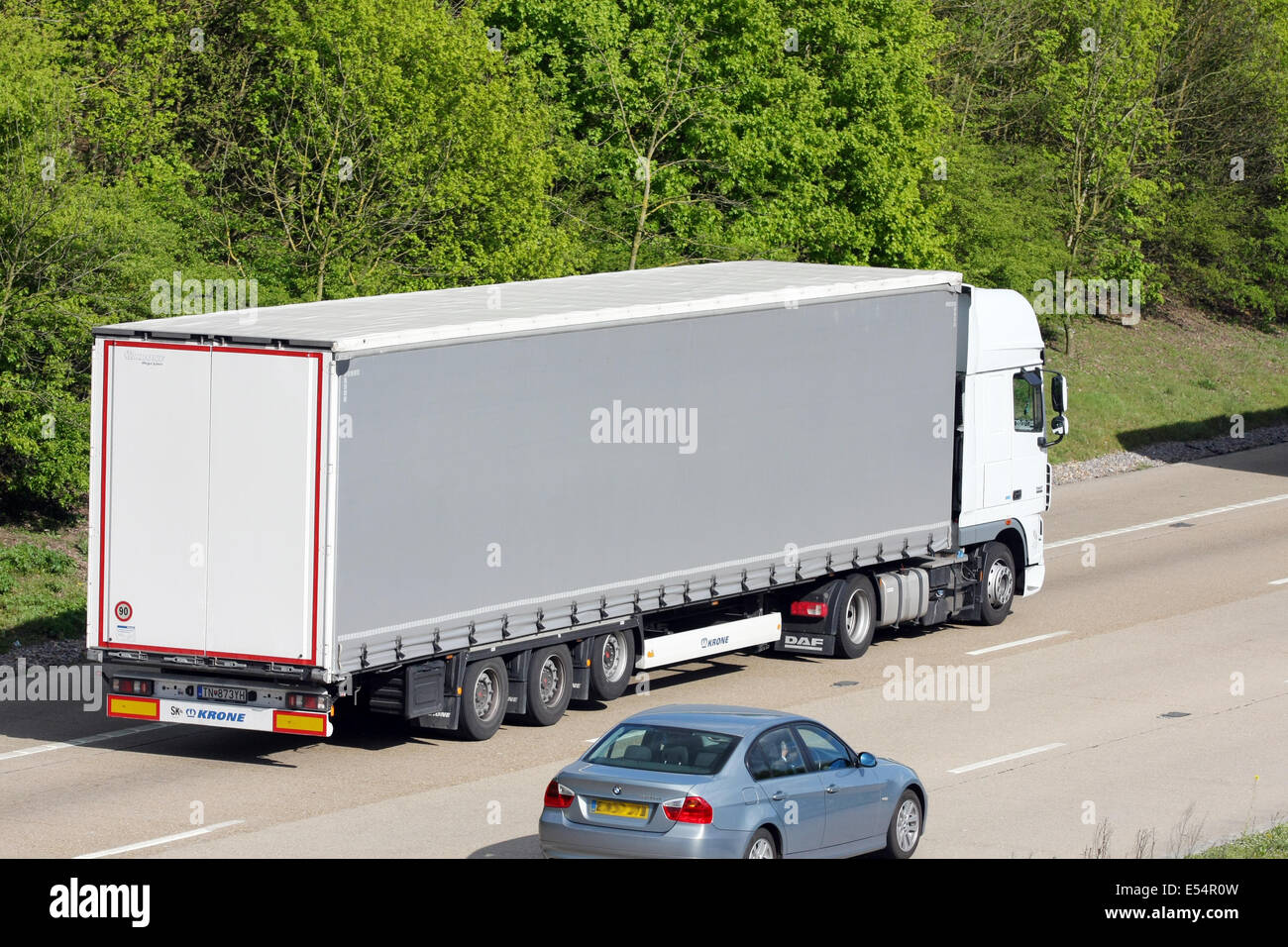 An unmarked articulated truck and a car traveling along the M20 motorway in Kent, England Stock Photo