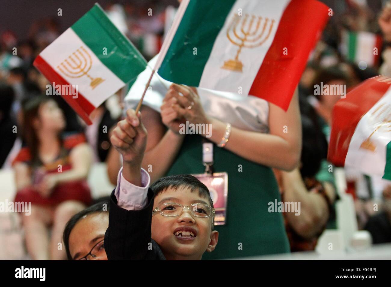 Bulacan, Philippines. 21st July, 2014. Bulacan, Philippines - A young follower of Inglesia Ni Ciristo waves his flag during the inauguration of the Philippine Arena on July 21, 2014. The inauguration of the multi-purpose complex was lead by Inglesia Ni Cristo Executive Minister Brother Eduardo V. Manalo and President Benigno Aquino III. The Philippine Arena, touted as the world's largest domed arena with a 55,000 seating capacity whose construction cost over $200 million is built to withstand strong earthquakes and super typhoon winds. Credit:  ZUMA Press, Inc./Alamy Live News Stock Photo