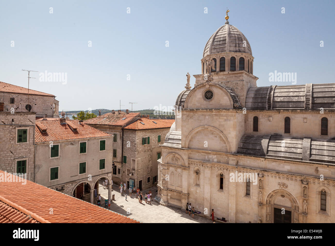 Cathedral of St. James in historic center of Sibenik, Croatia, with nearby buildings and tourists strolling around. Stock Photo