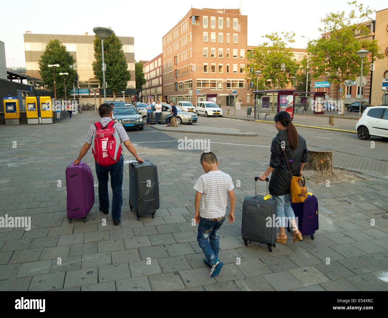 Traveling Family with suitcases looking for a taxi at Breda central train station, the Netherlands Stock Photo