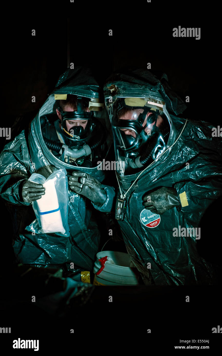 US Army national guard soldiers wearing HAZMAT Encapsulating Suits identify a potential radiological agent during a training exercise at the University of Mary May 6, 2014 in Bismarck, North Dakota. Stock Photo