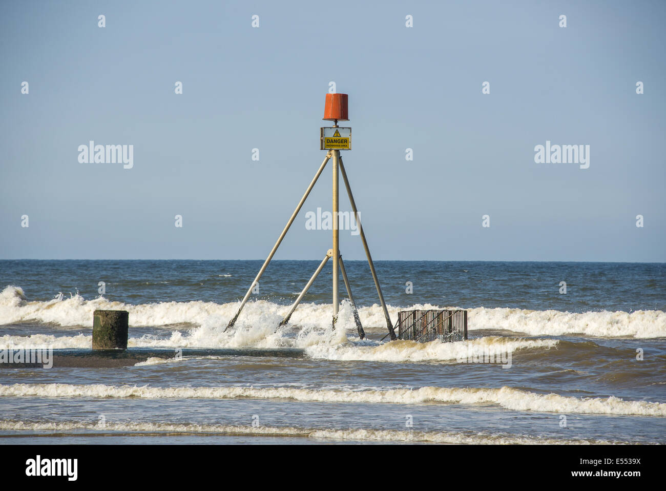 'Danger, Hazardous Area' sign on drainage outfall into sea, Anderby Creek, Lincolnshire, England, June Stock Photo