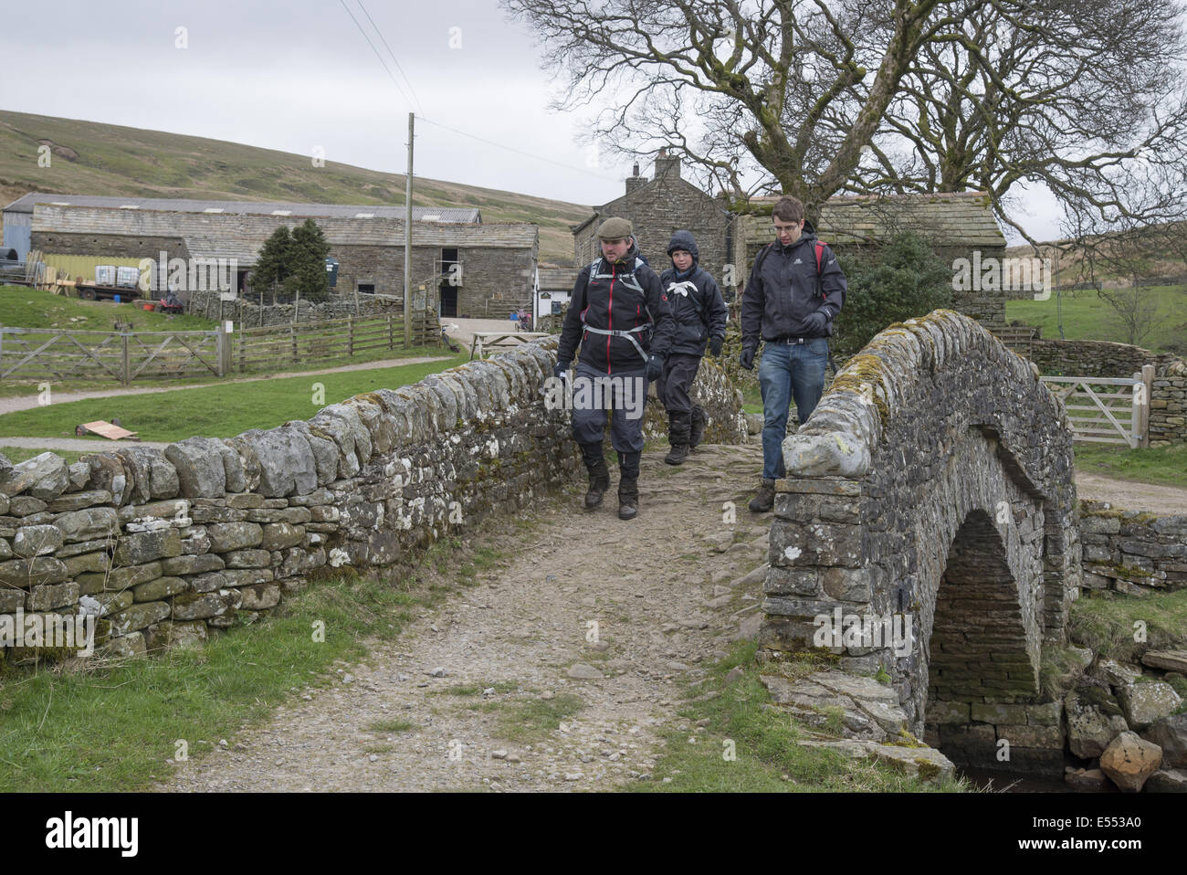 Walkers crossing bridge near farmyard on 'Coast to Coast Walk