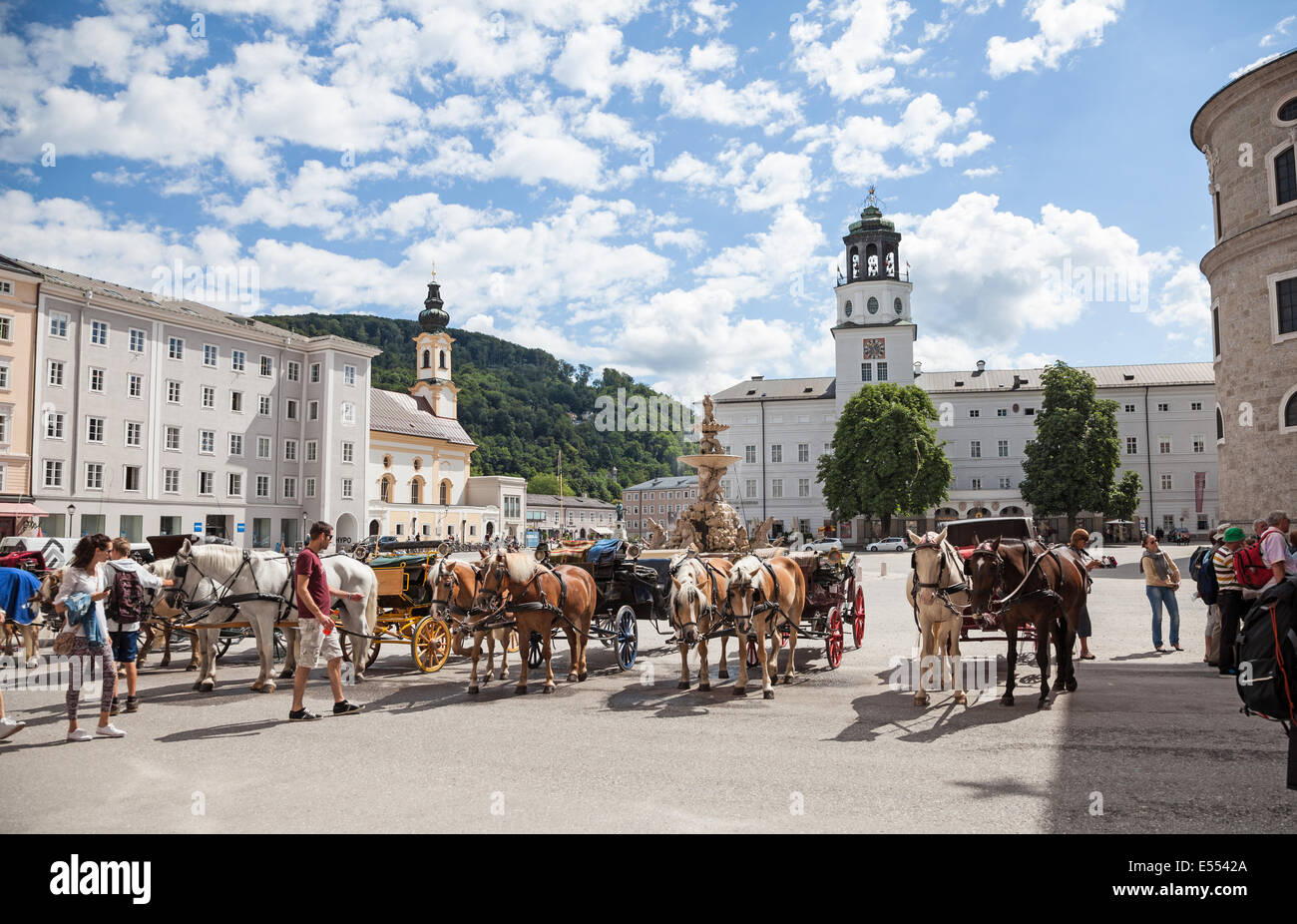 fiacres, a horse-drawn four-wheeled carriage, and their drivers waiting to be hired  Residenzplatz Salzburg Austria Europe Stock Photo