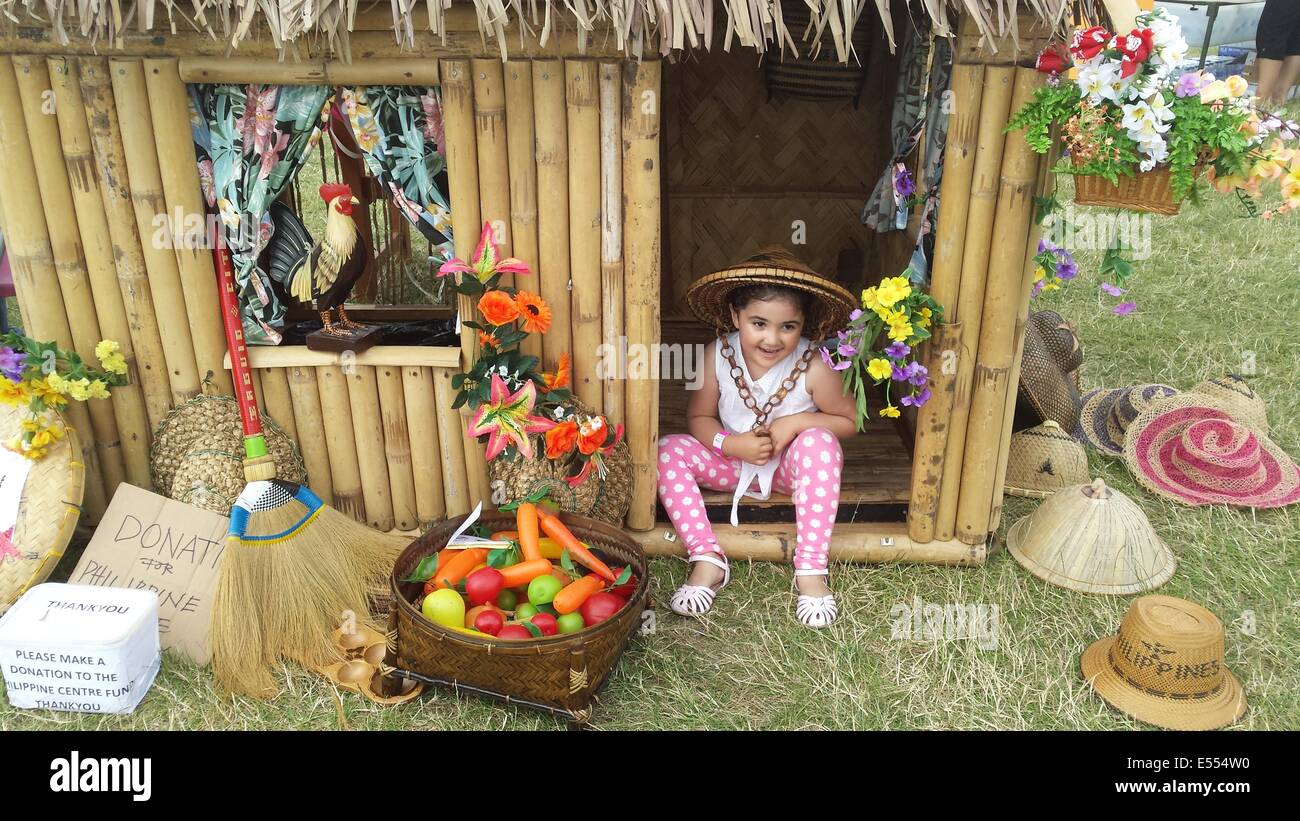 Walton, Surrey, UK. 20th July, 2014. Our daughter Faith enjoying the native filipino miniature house for philippine charity donations to show how to live and survive in a hot climate, living in poverty. Celebrating filipino culture and family values. Credit:  Paul Hamilton/Alamy Live News Stock Photo