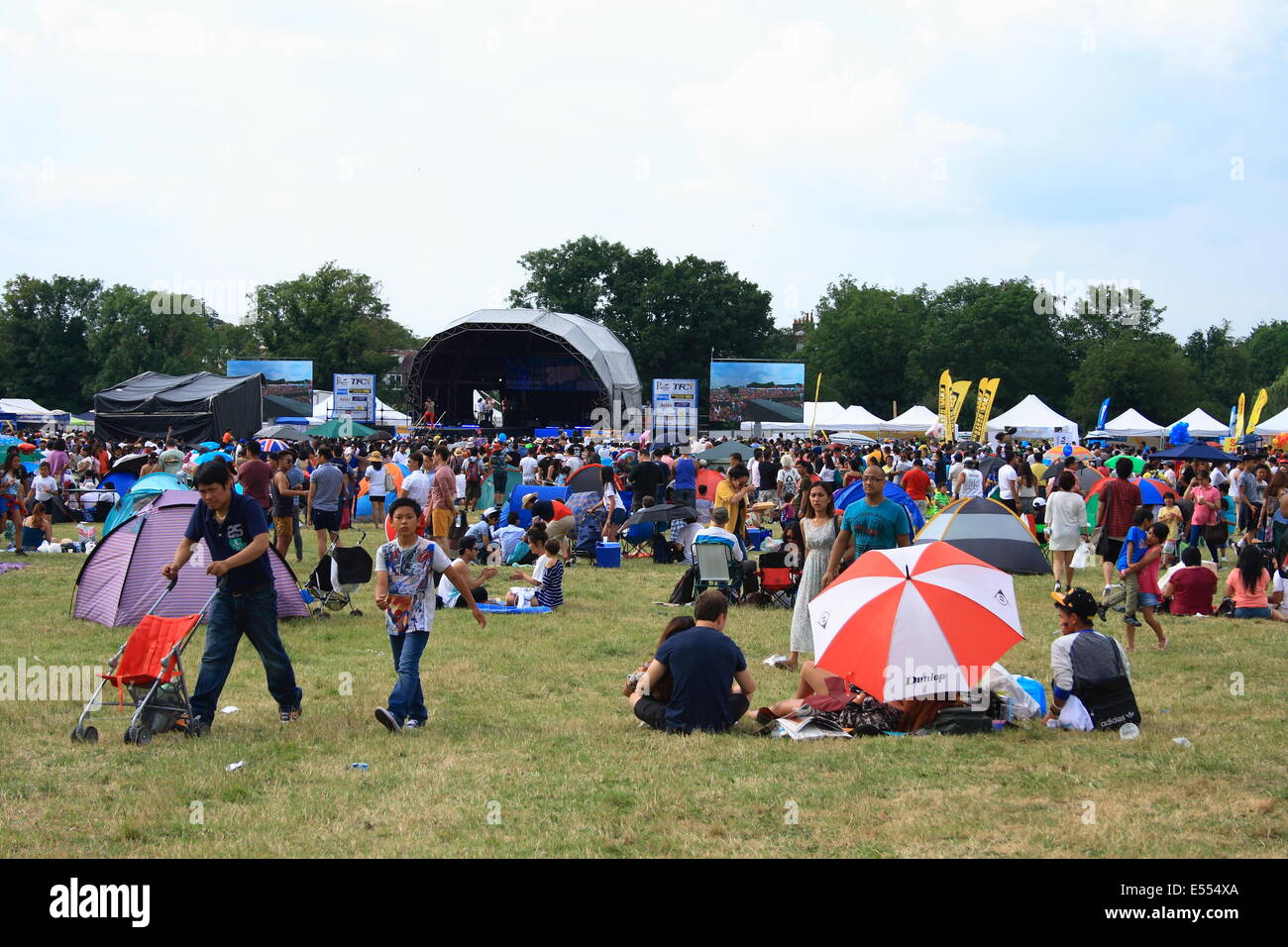 Walton, Surrey, UK. 20th July, 2014. Filipino's start gathering for the fiesta stage events to celebrate family day, all pitching tents and umbrellas for the day's event that will last for more than 12 hours. Credit:  Paul Hamilton/Alamy Live News Stock Photo