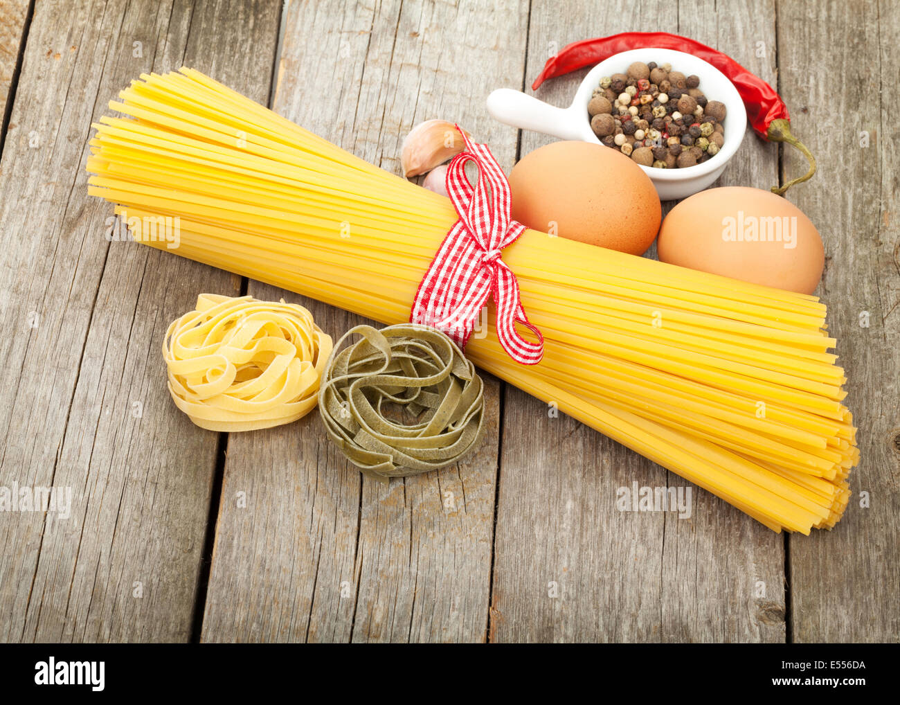 Pasta, eggs and spices on wooden table background Stock Photo