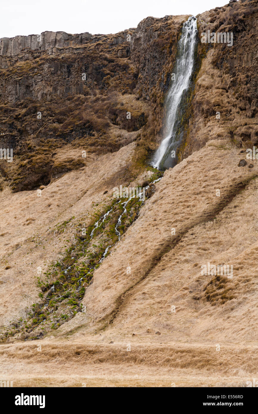 Waterfall cascading down rocks on the South Coast of Island Stock Photo