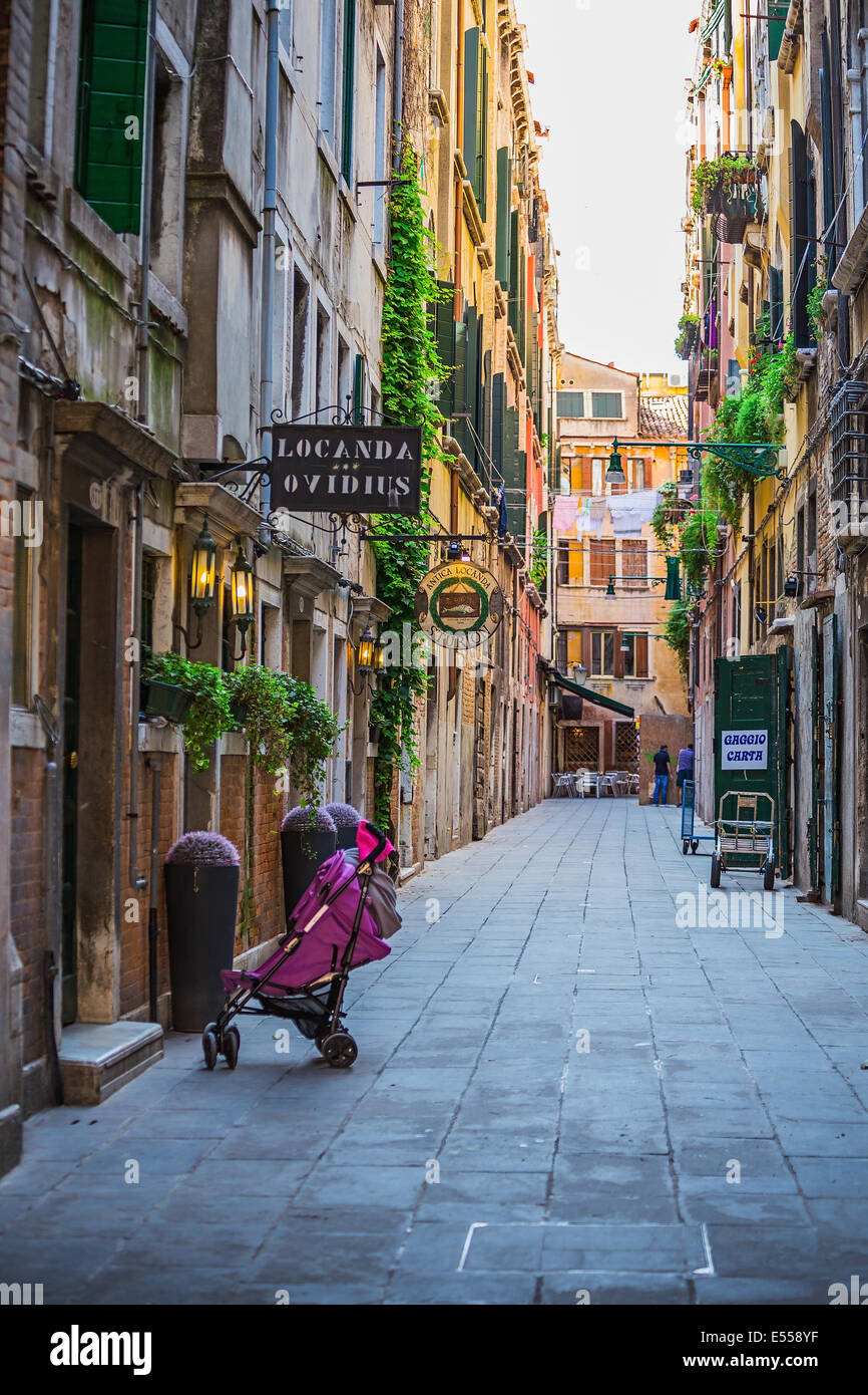 Narrow canal among old colorful brick houses in Venice, Italy Stock ...