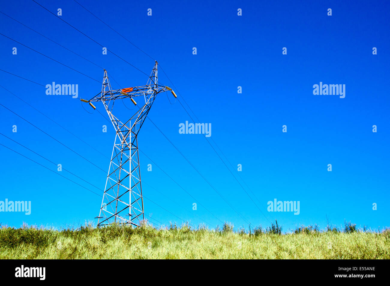 pylon against blue sky supporting electric power lines Stock Photo - Alamy