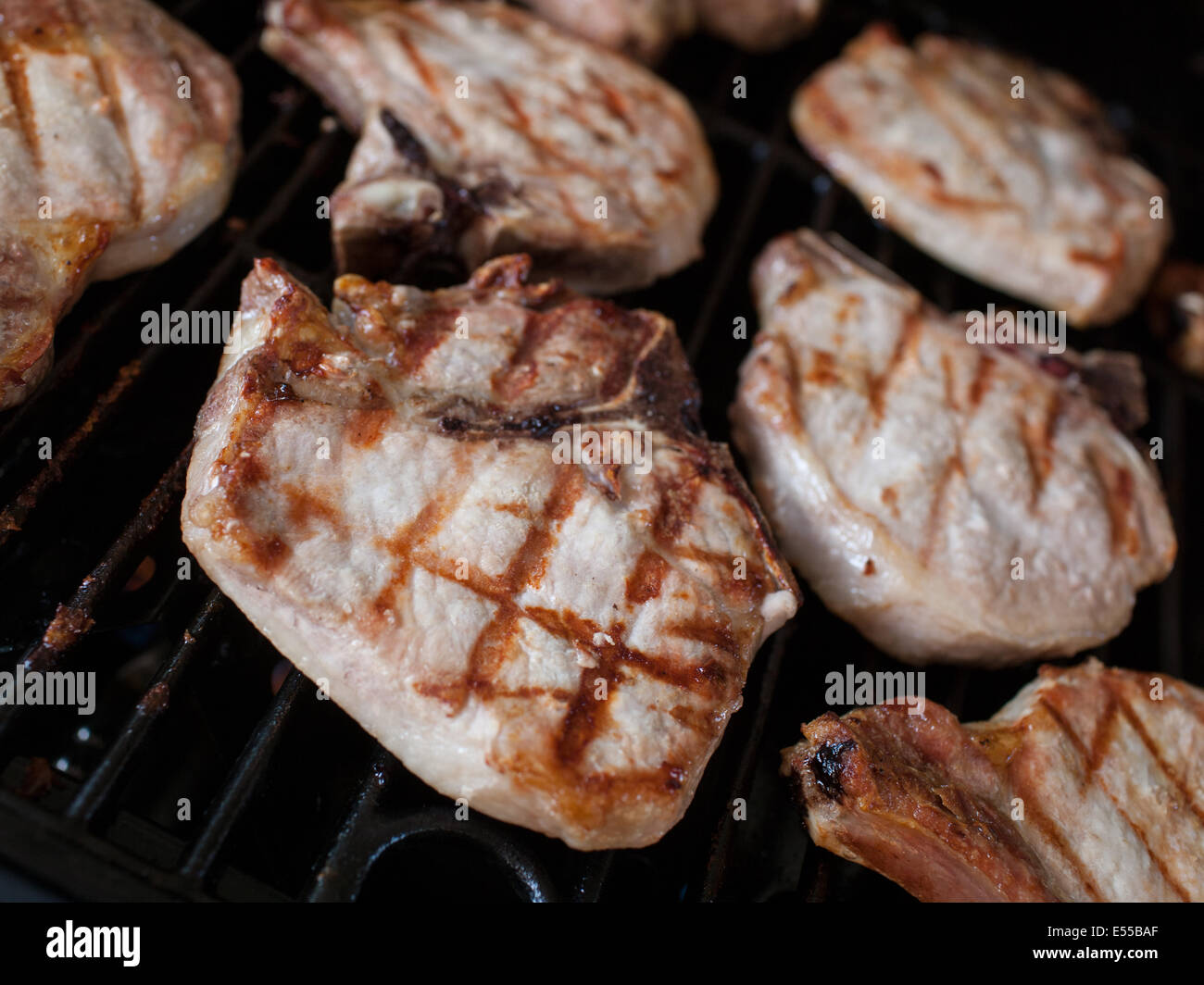 Pork Chops cooking on a grill Stock Photo