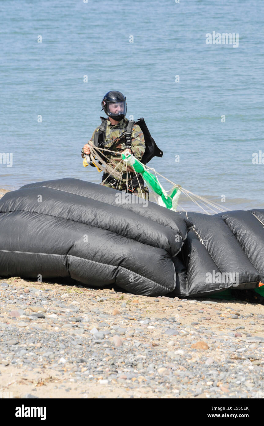 A member of the Black Knights Parachute team (from the Irish Defence Forces) collects his parachute after landing Stock Photo