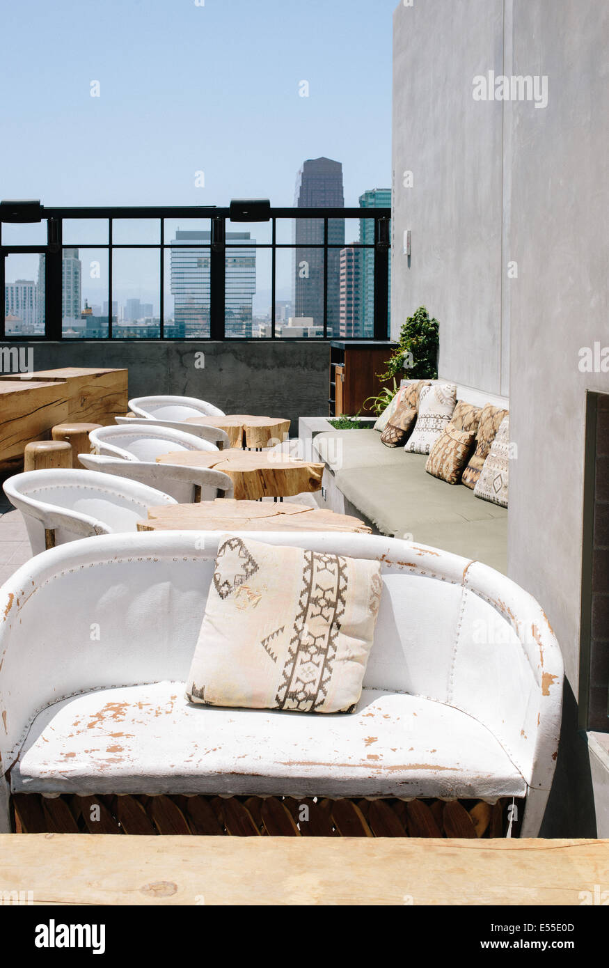 rooftop seating with distressed loveseats and los angeles skyline in