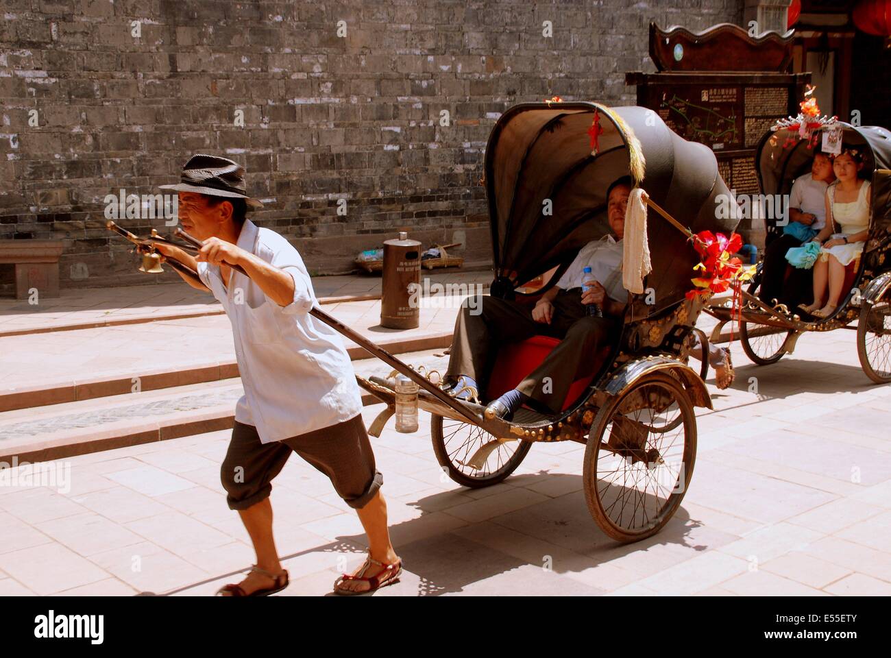 luo-dai-china-man-pulling-his-rickshaw-takes-visitors-for-a-ride-through-E55ETY.jpg