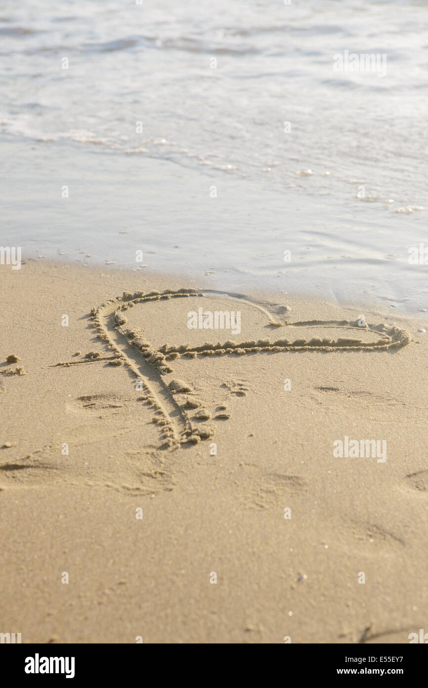 Drawing of heat in the sand next to ocean. Stock Photo