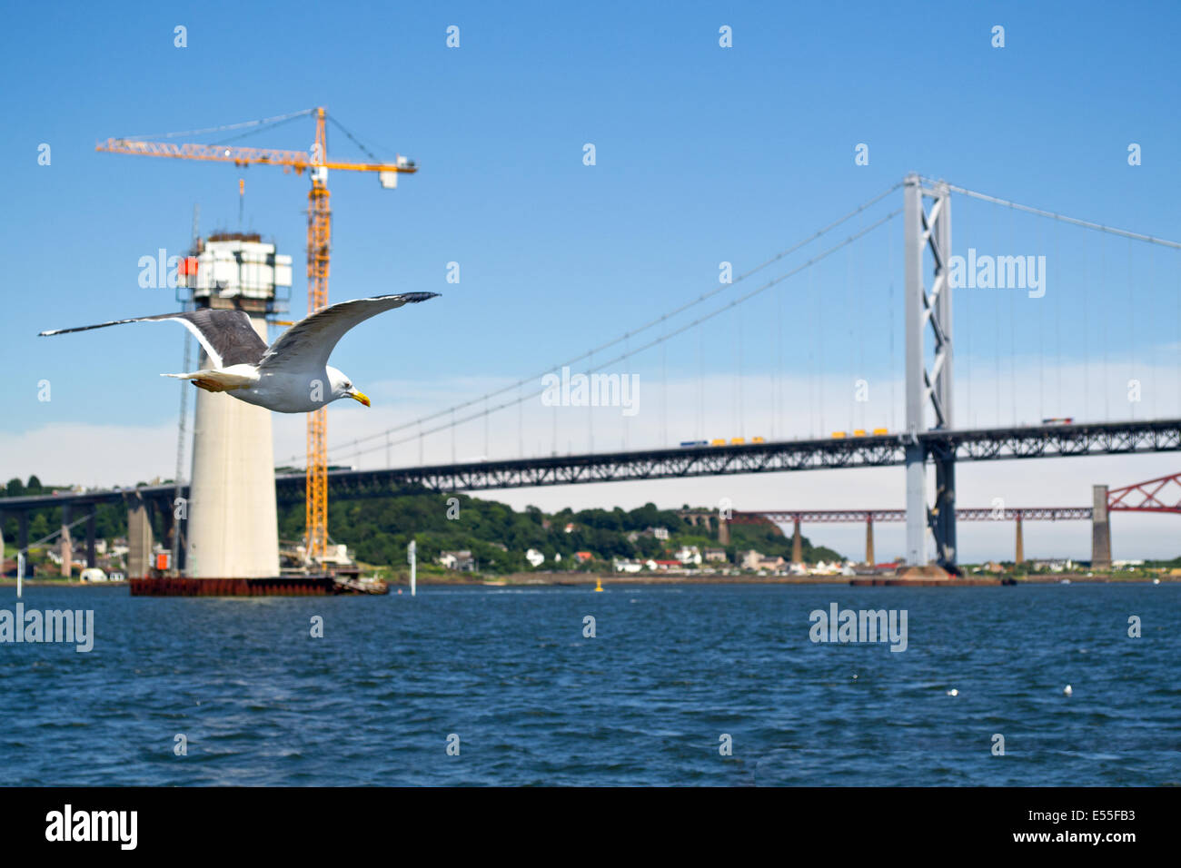 A view of the bridges crossing the Firth of Forth, Scotland. The pillar in the foreground is a foundation for the new crossing. Stock Photo