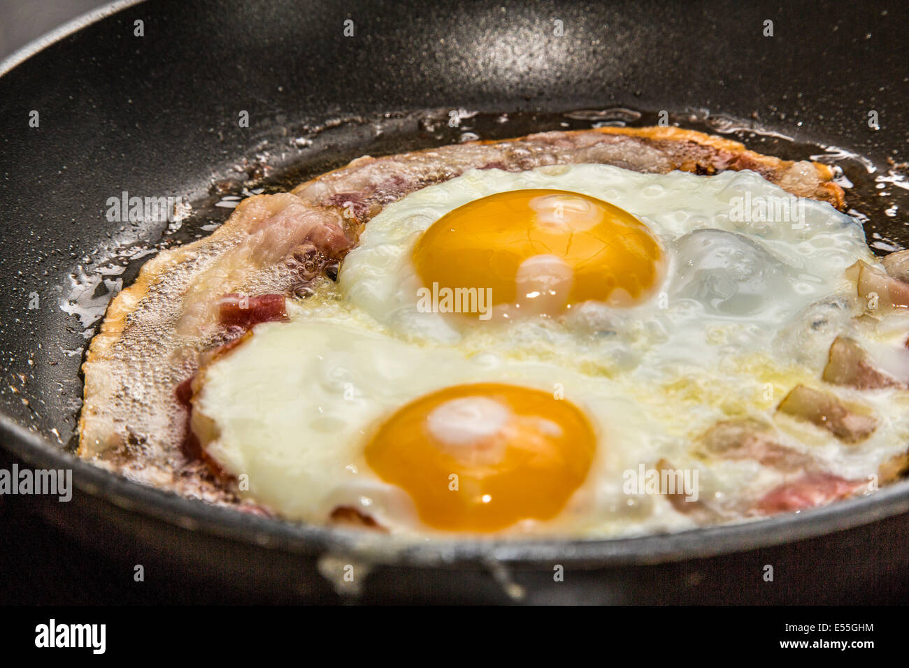 Fried eggs and bacon in a frying pan, breakfast, Stock Photo