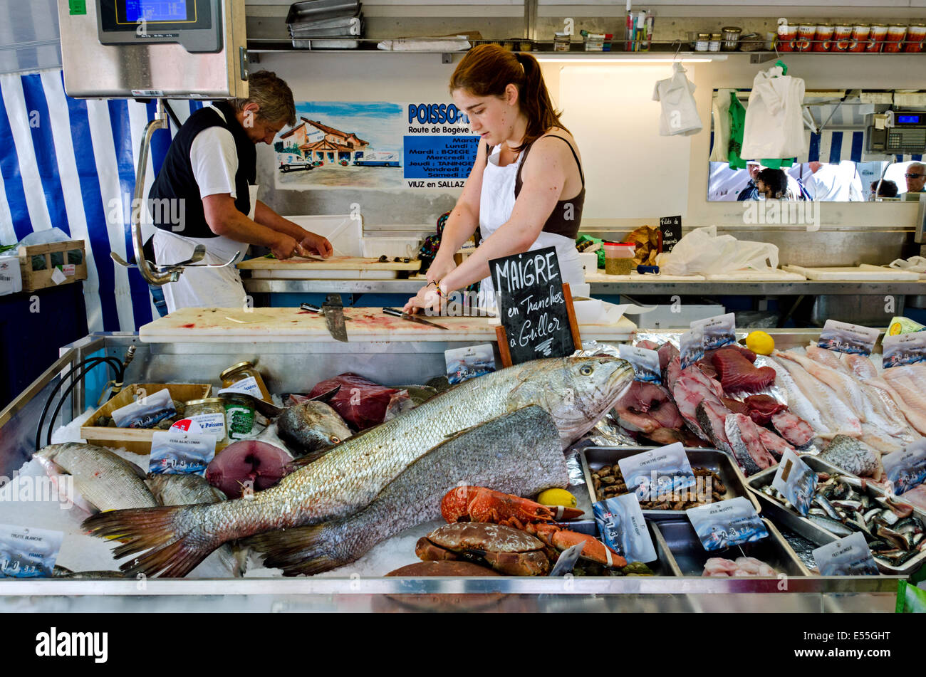 A man and young woman fillet fish at the Saturday morning Market in Chamonix, Haute Savoie, France. Stock Photo