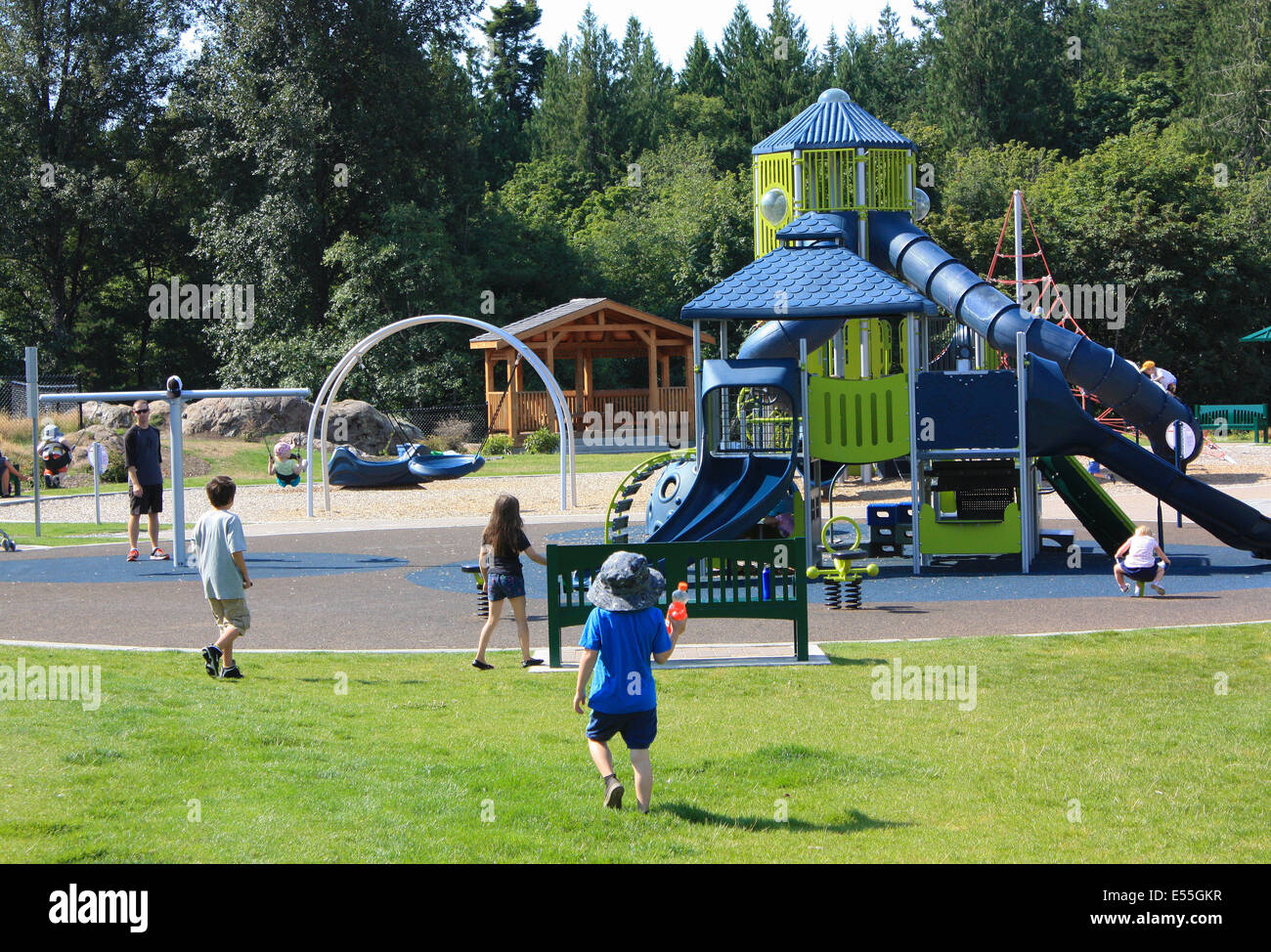 Children Having Fun in a Man Made Play Park with Slides Stock Photo