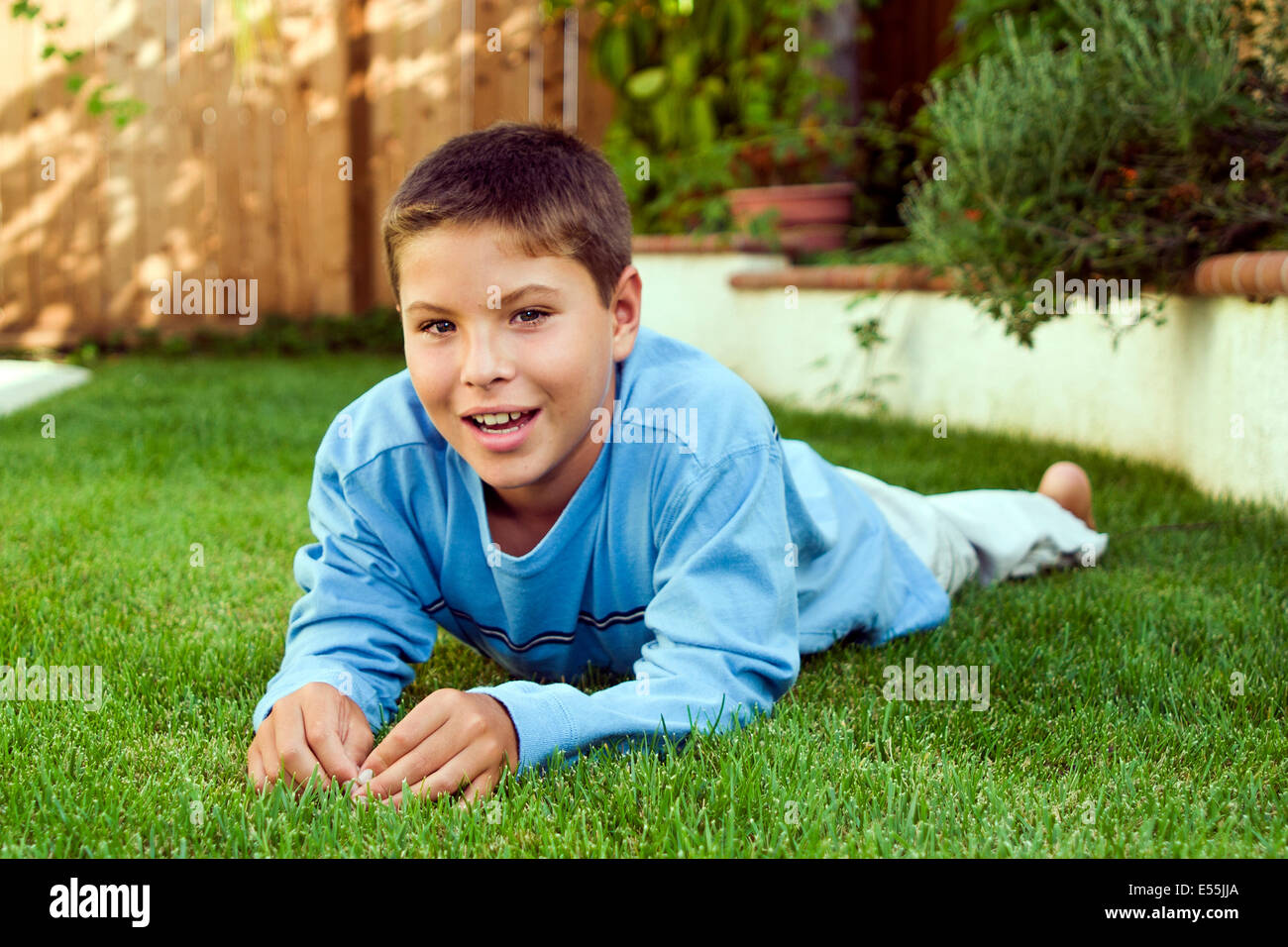 9-10 year old young person people Smiling Japanese/Caucasian boy laying on grass in backyard eye contact MR © Myrleen Pearson Stock Photo