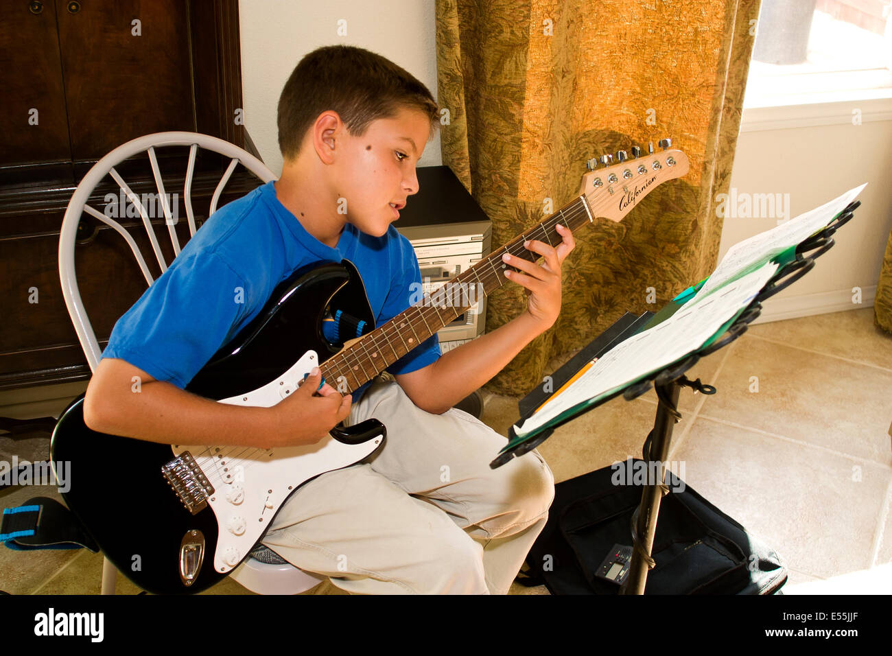 young Japanese Caucasian boy playing guitar.  MR © Myrleen Pearson Stock Photo