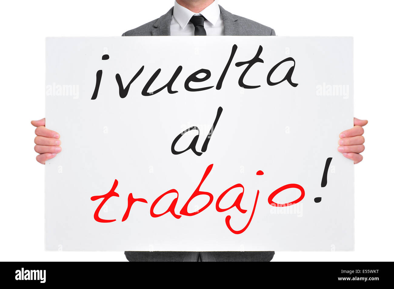 businessman holding a signboard with the text vuelta al trabajo, back to work in spanish, written in it Stock Photo