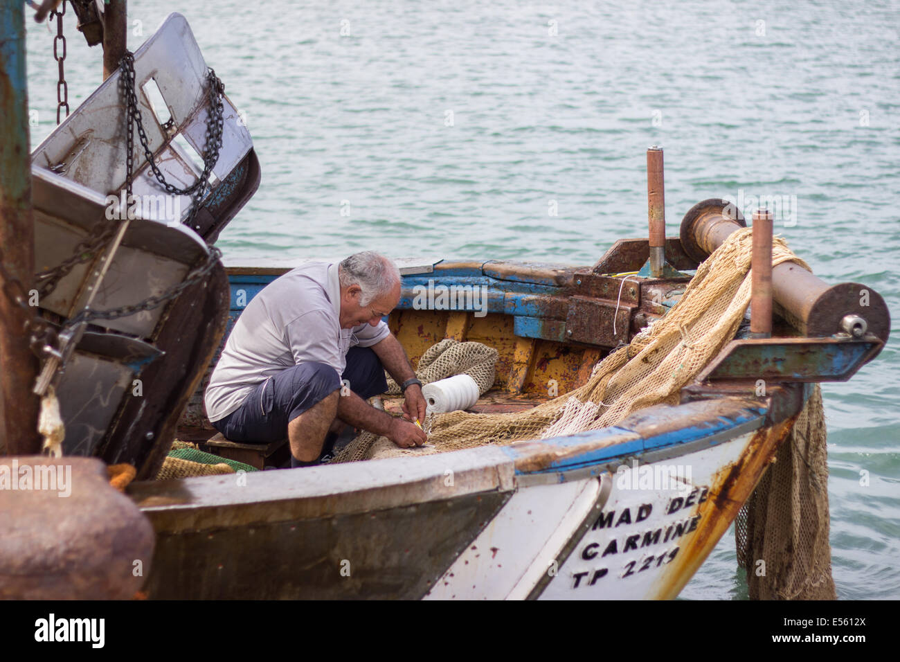 fisher man weaving fishing net  fishnet commercial vessel boat sea industry Stock Photo