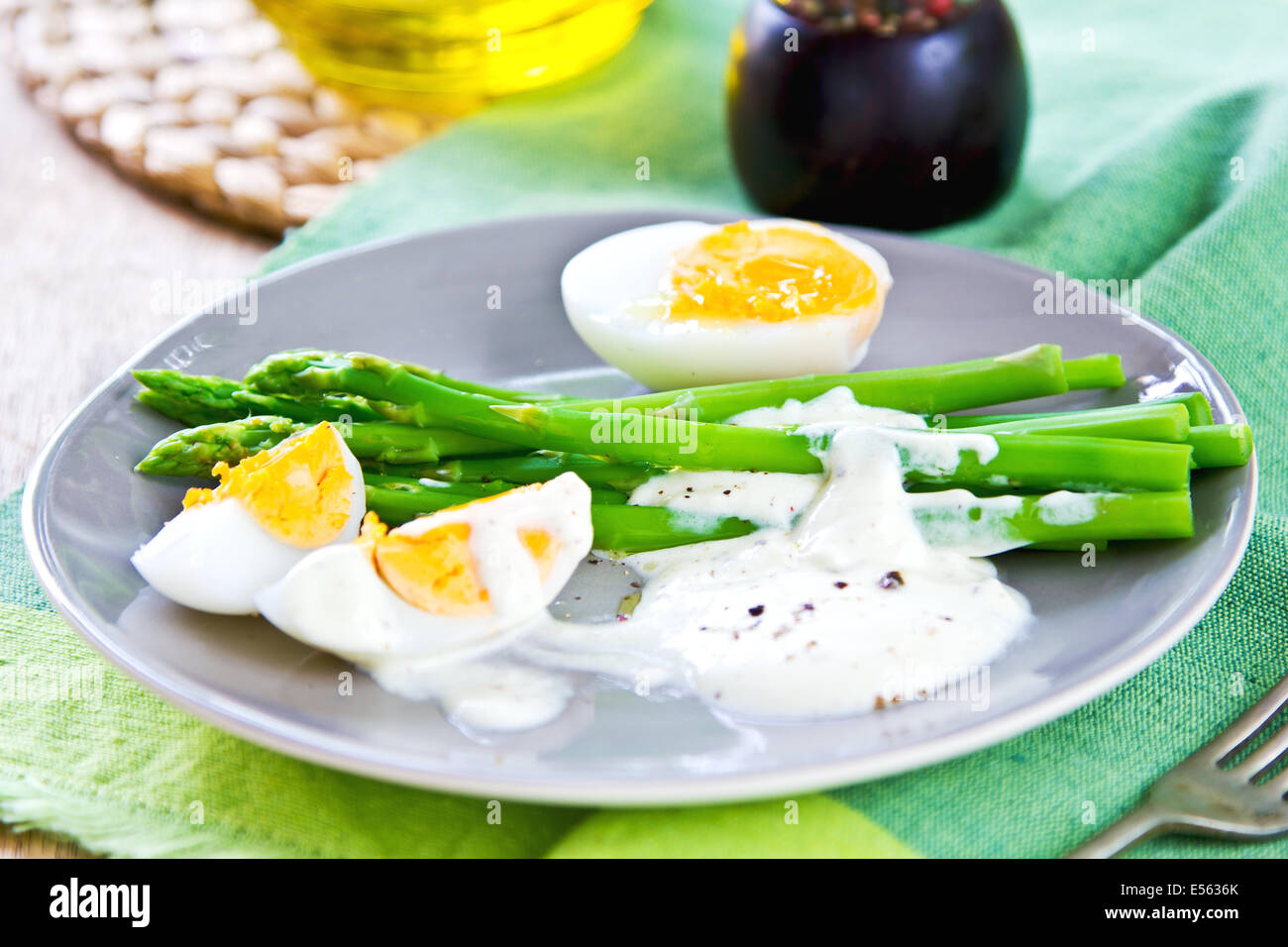 Steamed Asparagus with boiled eggs and sour cream dressing Stock Photo