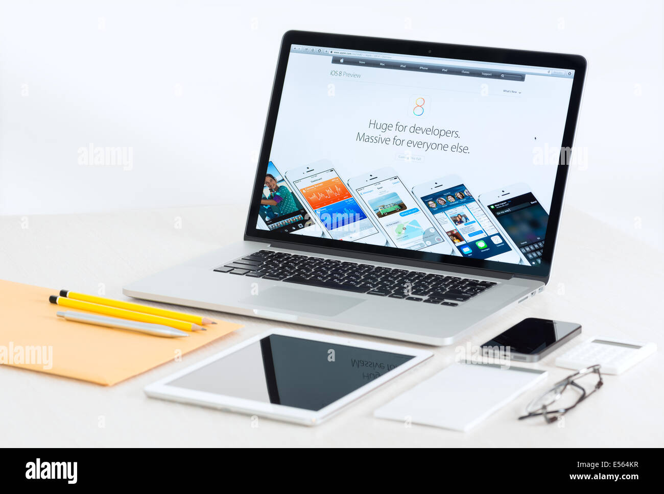 Studio shot of brand new Apple MacBook Pro with Apple mobile devices presenting iOS 8 for developers Stock Photo