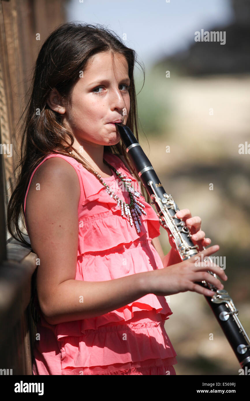 Young girl of 12 plays the clarinet outdoors. Model release available Stock Photo