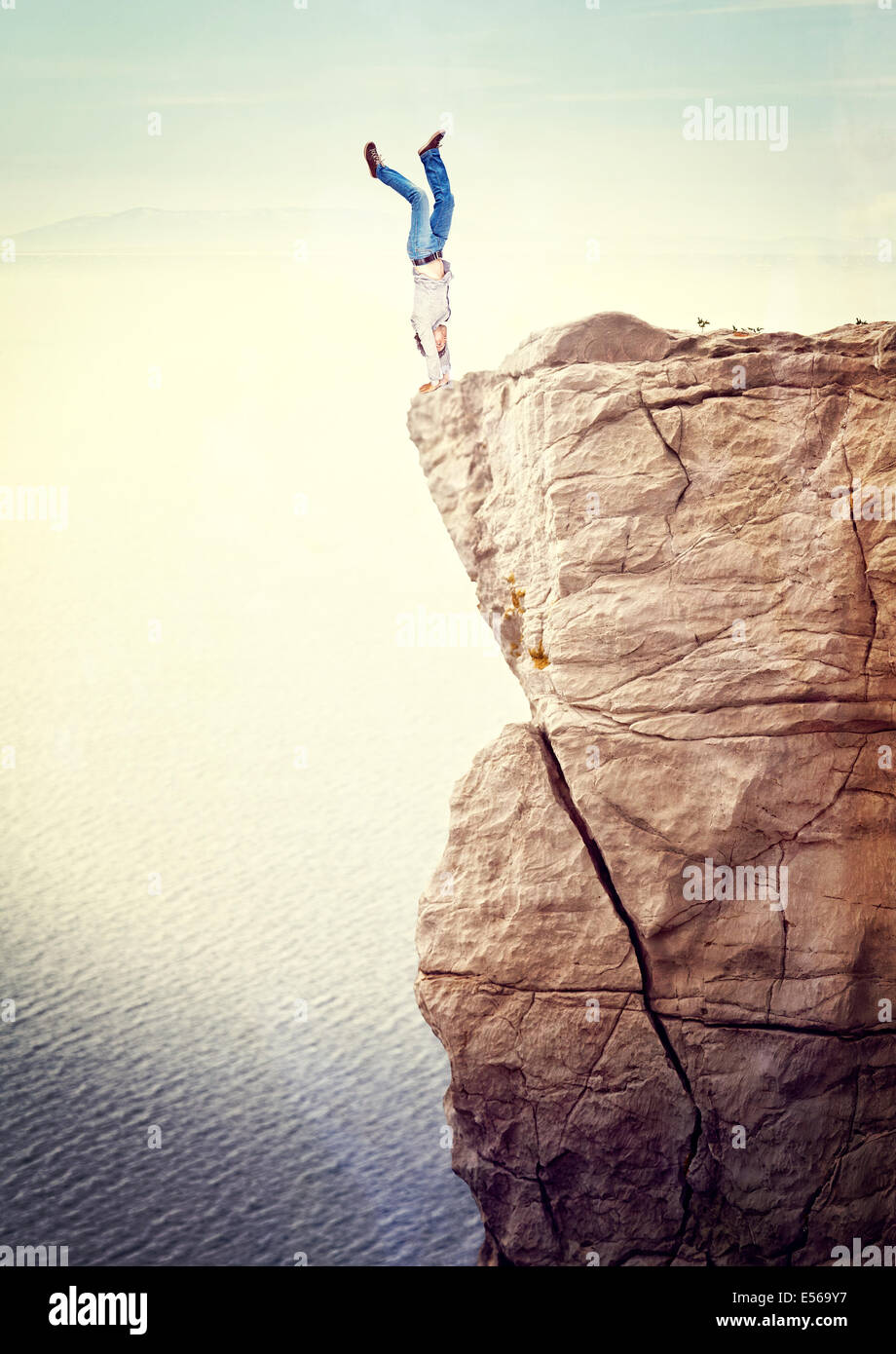 man acrobat on dangerous cliff Stock Photo