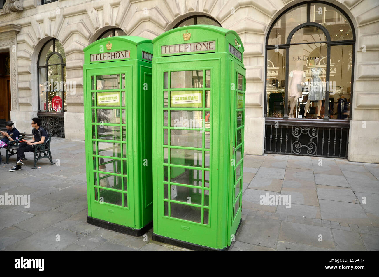 Two green telephone boxes next to London's Royal Exchange bearing stickers for the Samaritans organisation. Stock Photo