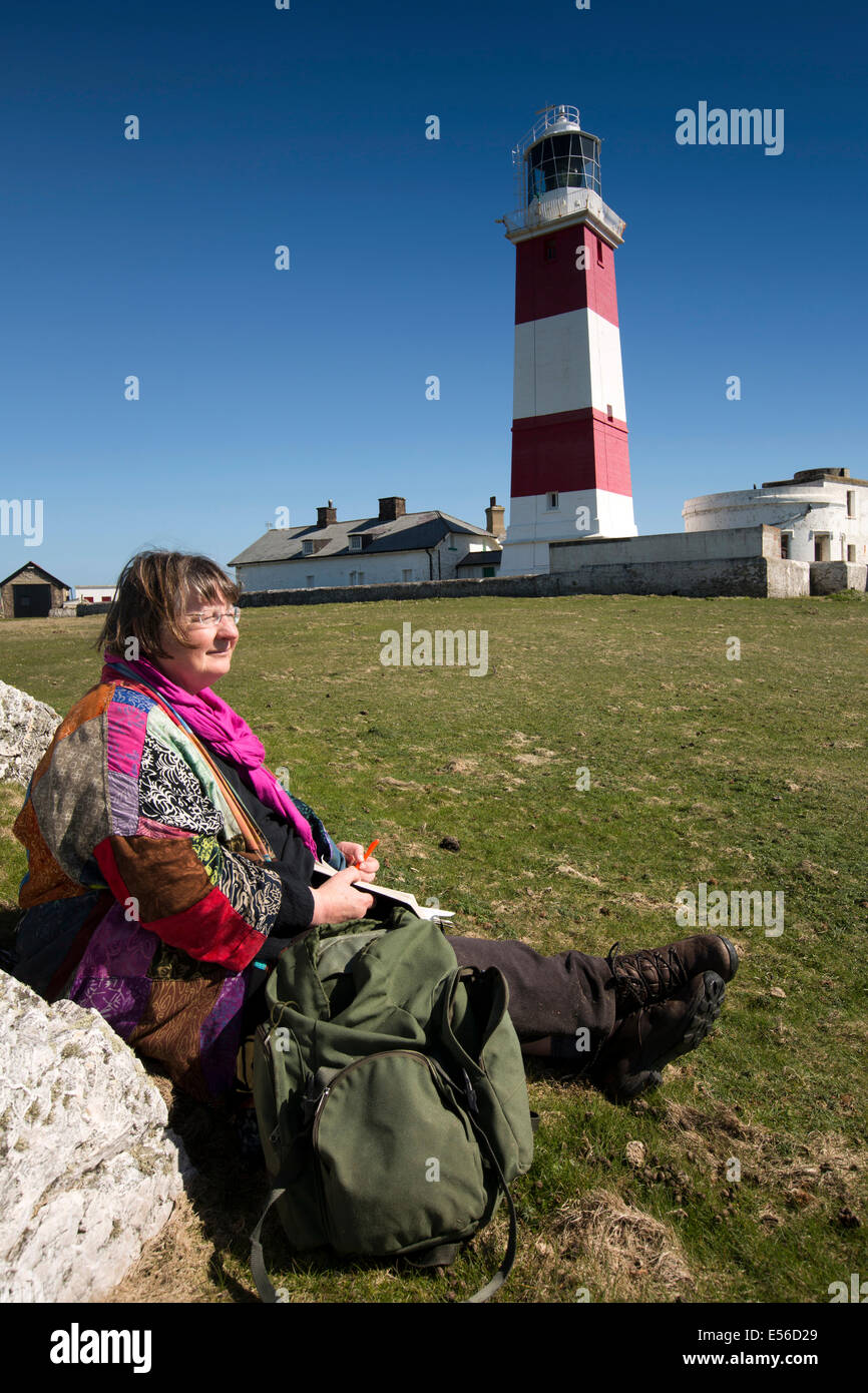 UK, Wales, Gwynedd, Lleyn peninsula, Bardsey Island, lighthouse, visitor engaged in religious contemplation Stock Photo