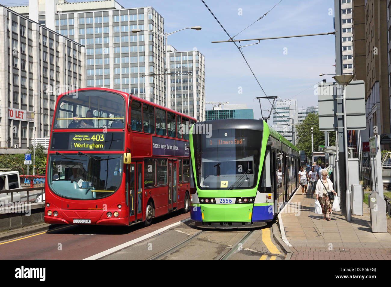 A Tram on the Croydon Tramlink system stops on Wellesley Road in Croydon town centre. A London bus passes. Stock Photo