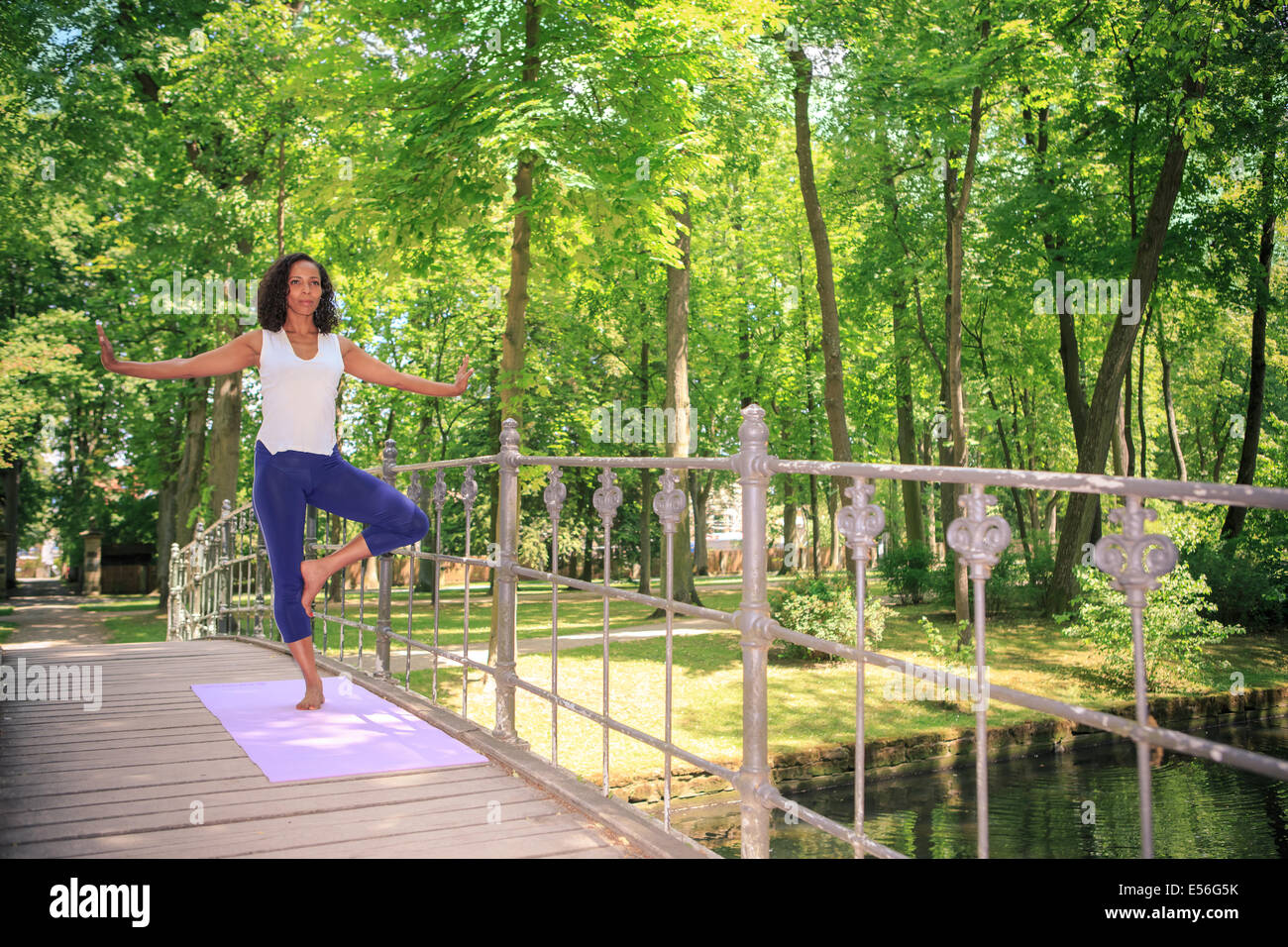 woman making yoga exercise in an old park Stock Photo