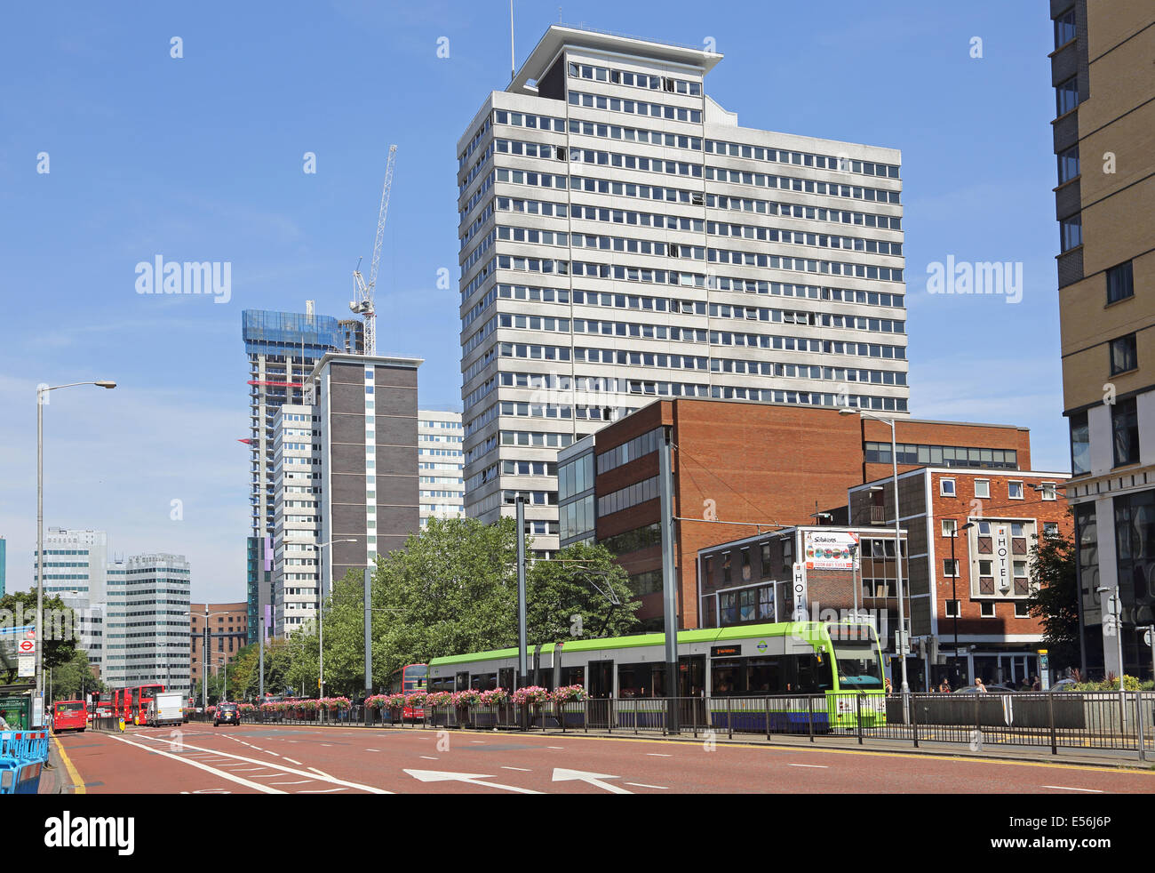 A tram travels down Wellesley Road, Croydon, UK. A modern, urban dual carriageway with existing and new office blocks. Stock Photo