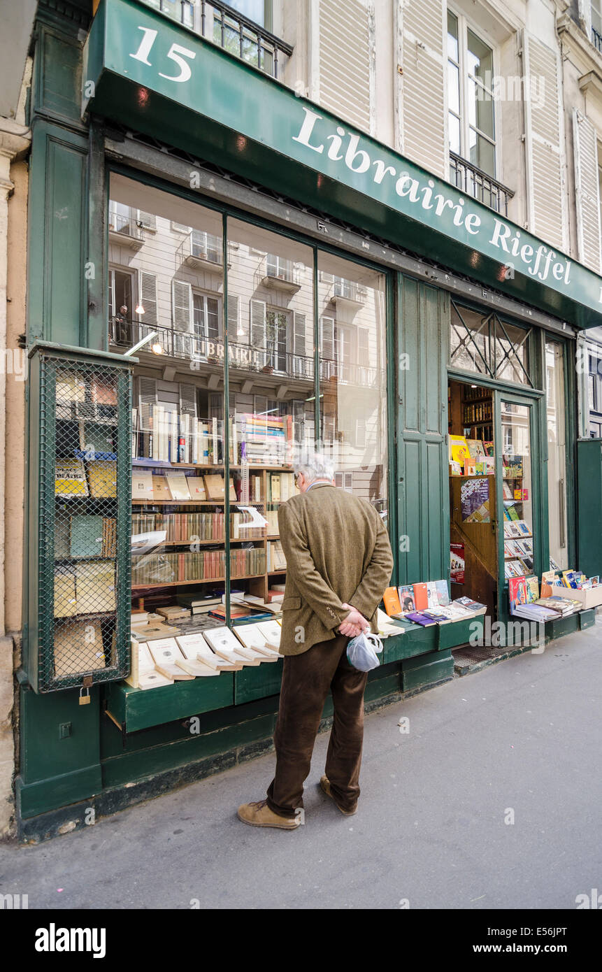 A man looks through the window of an old traditional Parisian book shop in Paris, France Stock Photo