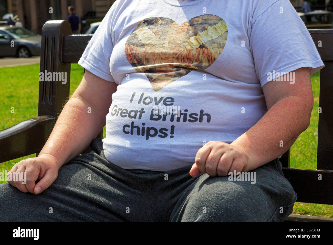 Overweight man wearing a tee shirt advertising chipped potatoes, Glasgow, Scotland, UK Stock Photo