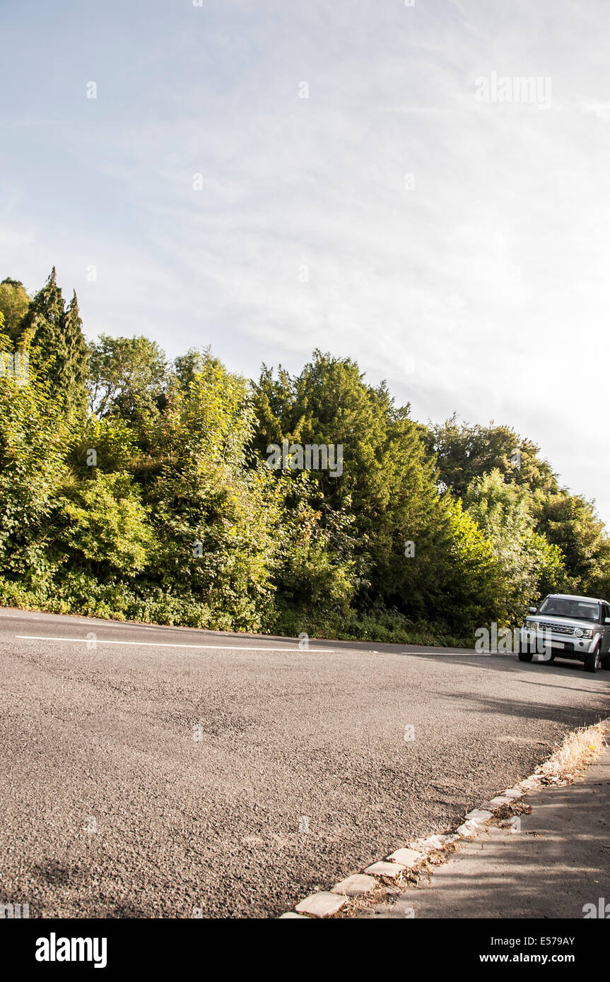 Car driving down a country lane in the Cotswolds United Kingdom Stock Photo