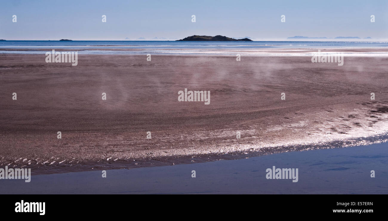 Panoramic view of steam rising from the sand as the morning sun heats the beach Stock Photo