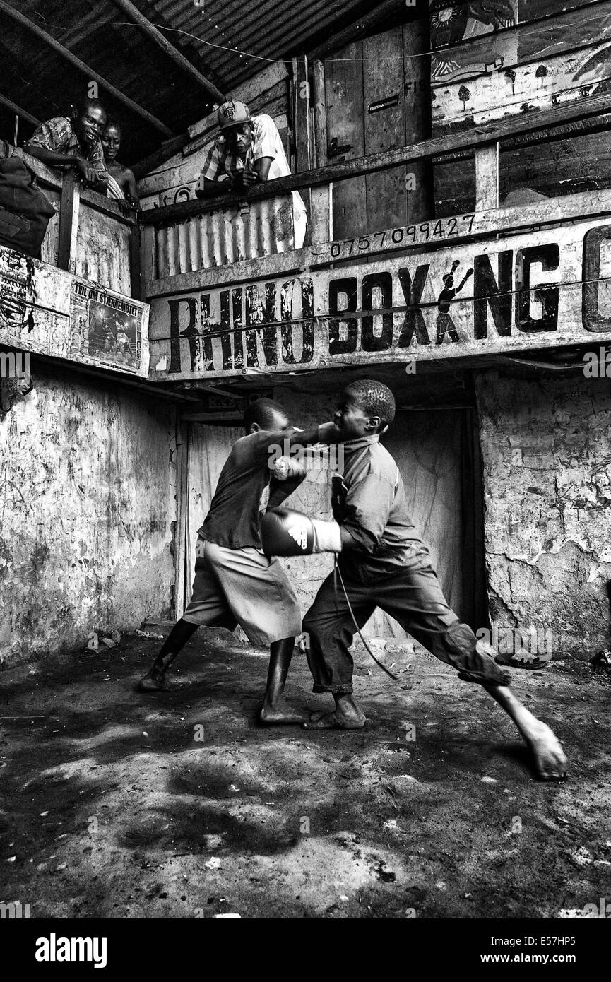 Jul 27, 2013 - Kampala, Uganda - Kids Boxing at the Rhino Boxing Club. Katanga in Kampala is a slum community where more than 20,000 people live under conditions of extreme poverty and without basic infrastructure such as permanent fresh water supply and brick houses, Amidst the shanty homes a group of ambitious fighters are trying to reach for a better life. Whilst gathering banana peels in order to survive, they are passionate about boxing, and they continue their struggle despite the scorn, which is often uttered openly. The Rhino Boxer Club in the midst of the slums of Katanga, allowing fo Stock Photo