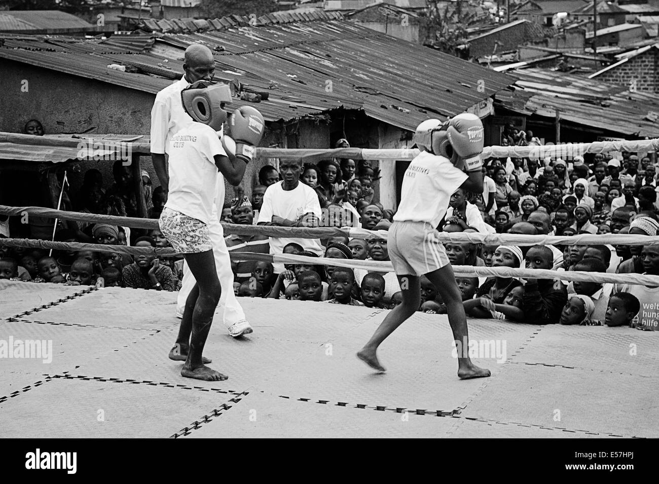 Aug 31, 2013 - Kampala, Uganda - Kids Boxing at the Rhino Boxing Club during a boxing event. Katanga in Kampala is a slum community where more than 20,000 people live under conditions of extreme poverty and without basic infrastructure such as permanent fresh water supply and brick houses, Amidst the shanty homes a group of ambitious fighters are trying to reach for a better life. Whilst gathering banana peels in order to survive, they are passionate about boxing, and they continue their struggle despite the scorn, which is often uttered openly. The Rhino Boxer Club in the midst of the slums o Stock Photo