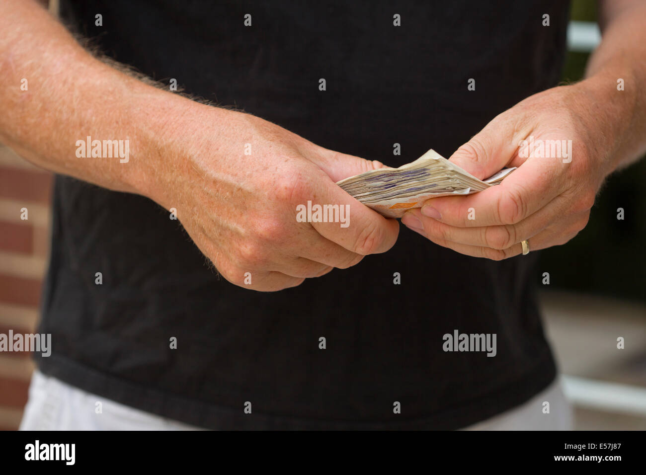 Handing over UK cash notes. Counting money maybe about to pay in cash.Money is UK cash sterling. Stock Photo