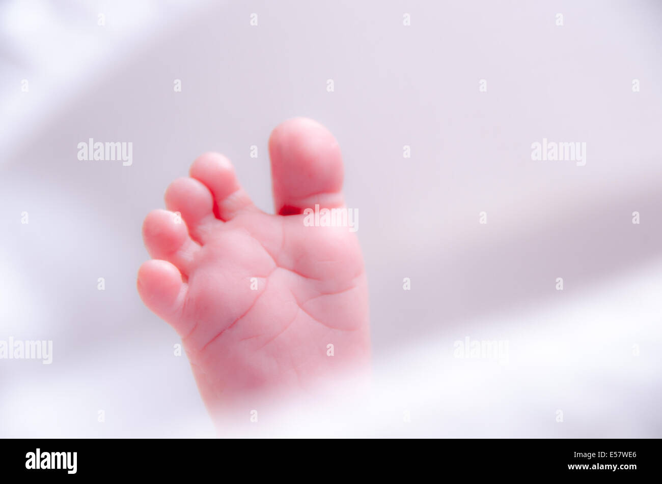 Newborn baby stretching out in a light and airy nursery moses basket Stock Photo