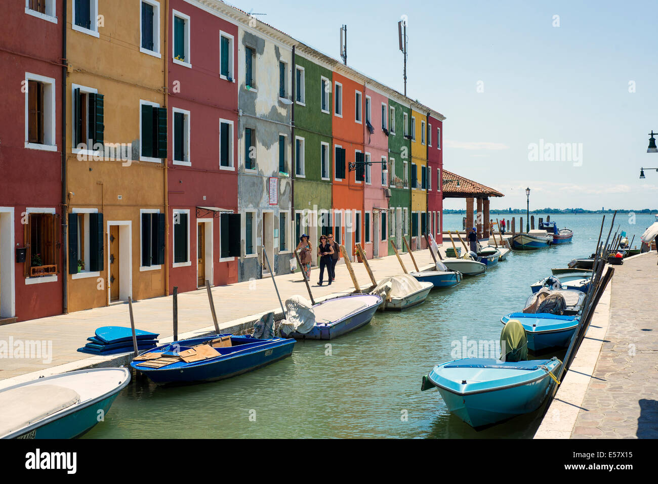 Tourists walk on a street of colored houses in Burano Stock Photo