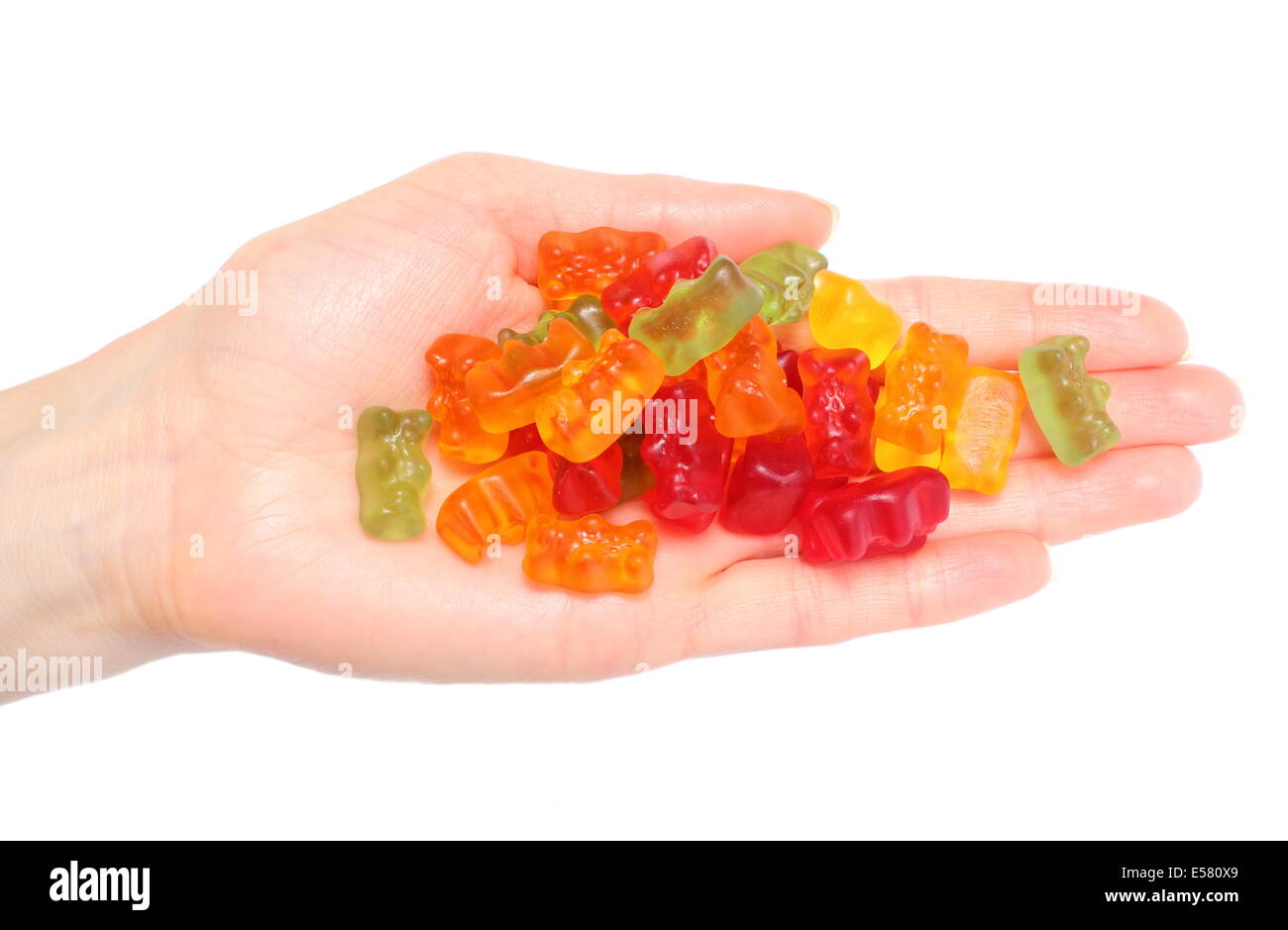 Lots of colorful haribo bear candies in hand of woman. Isolated on white background Stock Photo